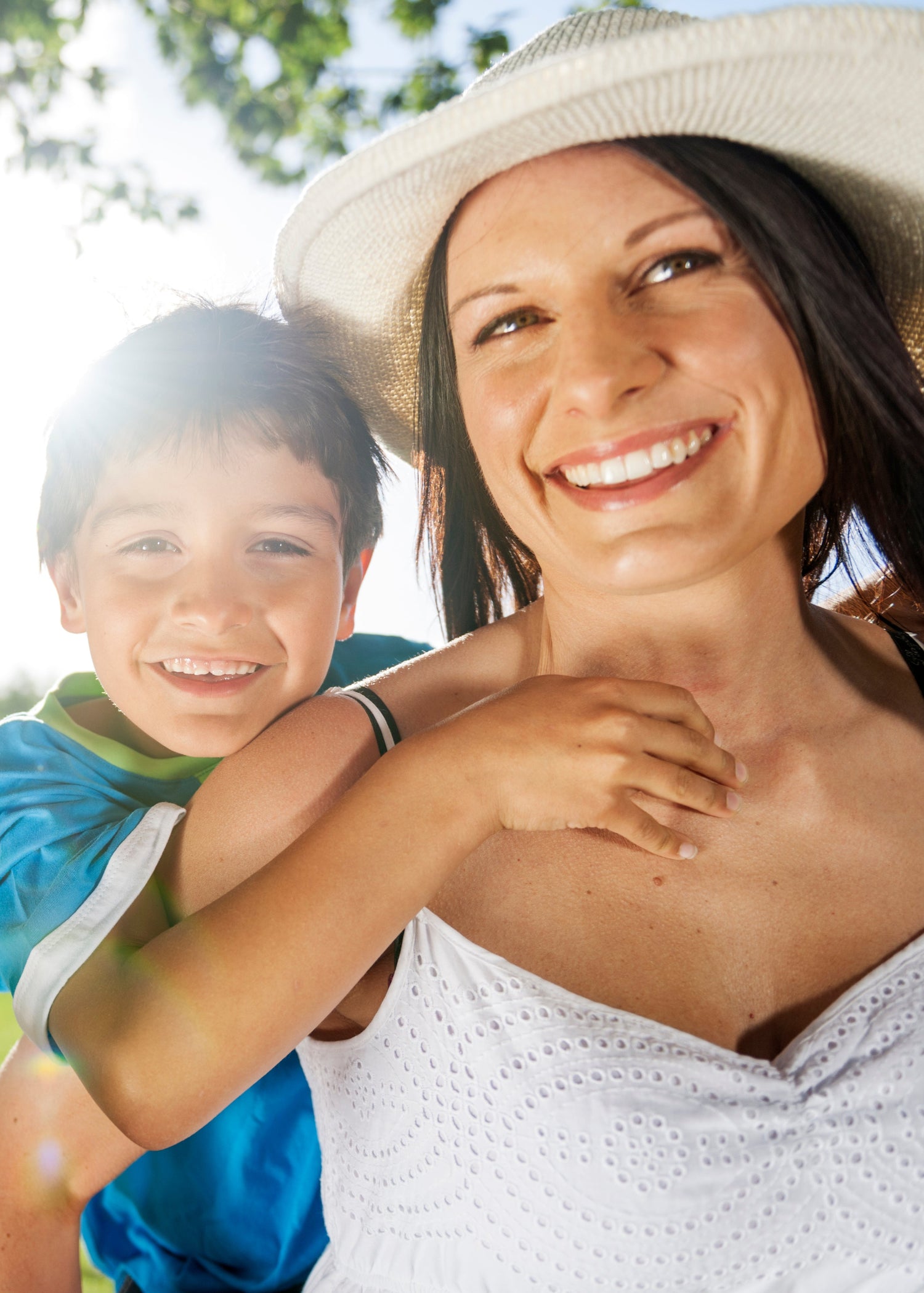 Family of four smiling outdoors with a blurred background